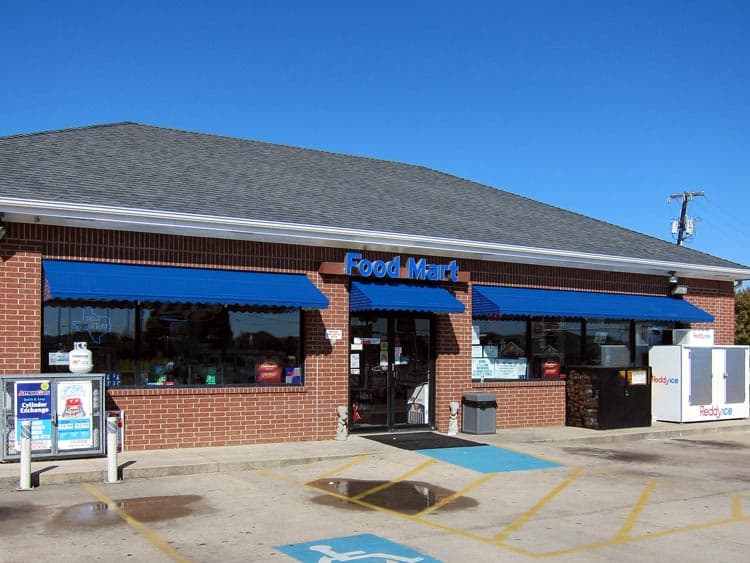 Blue aluminum awnings over gas station store front